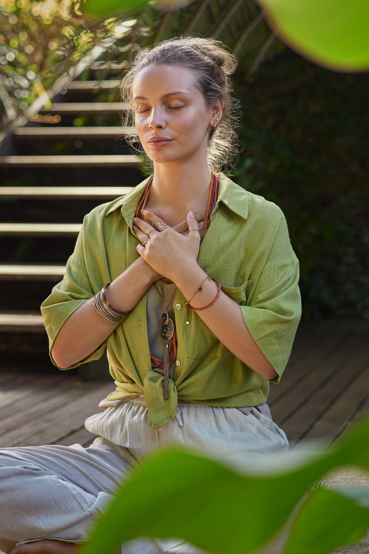 Person sitting peacefully with hand on heart practicing somatic healing